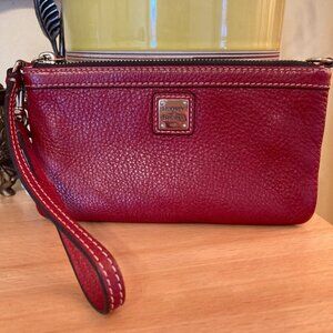Dooney & Bourke handbag in red textured leather, with a zipper closure.